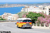 With Mellieha Bay and the island of Comino visible in the background, AEC Mercury DBY308 chugs its way up the hill into Mellieha town.